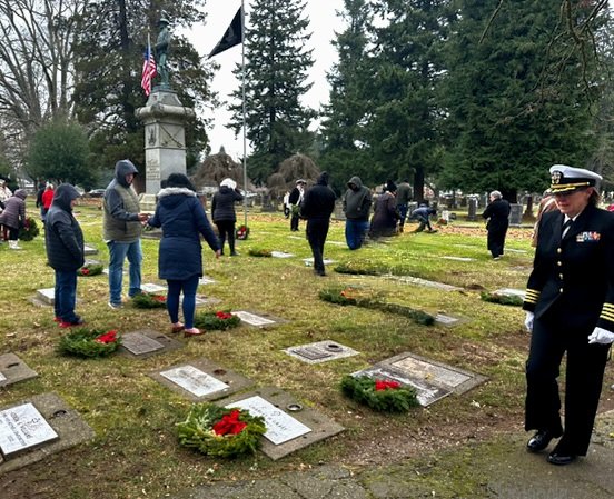 Captain Dykstra observes, walking through the cemetery during wreath placement.